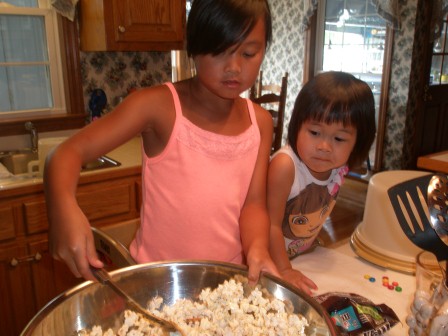 Kasen and Karis making Daddy's popcorn cake
